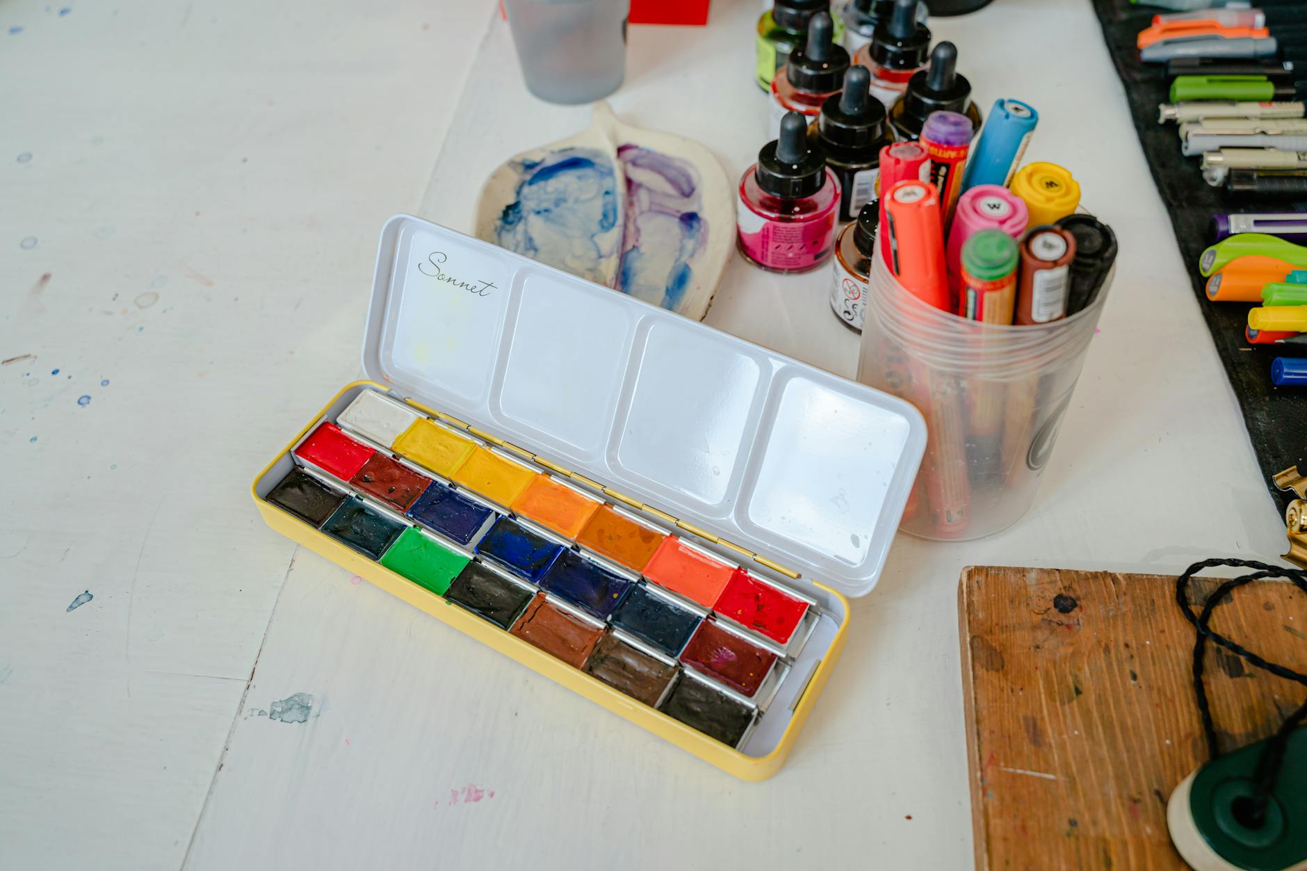 Kolorowe akcesoria plastyczne na biurku w kreatywnej pracowni