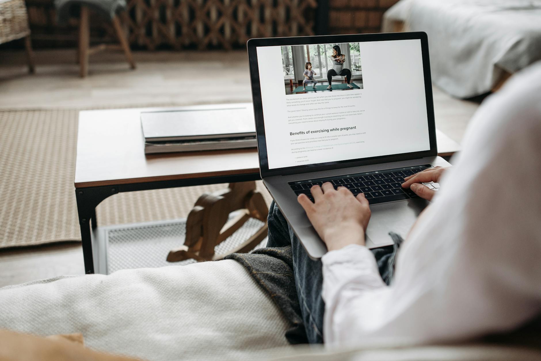 Osoba pracuje zdalnie na laptopie w przytulnym domowym wnętrzu