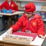 Samoobsługa w szkole: co ustalić z personelem, by dziecko miało realną niezależność Dziecko pracuje samodzielnie przy materiale Montessori w jasnej klasie