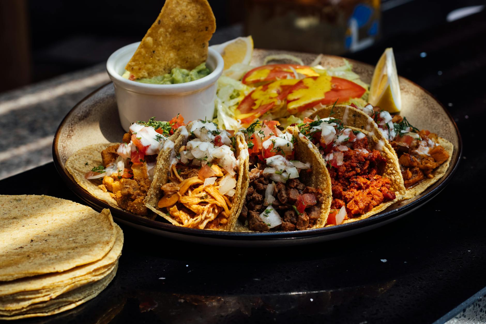 Talerz kolorowych tacos al pastor z świeżymi dodatkami