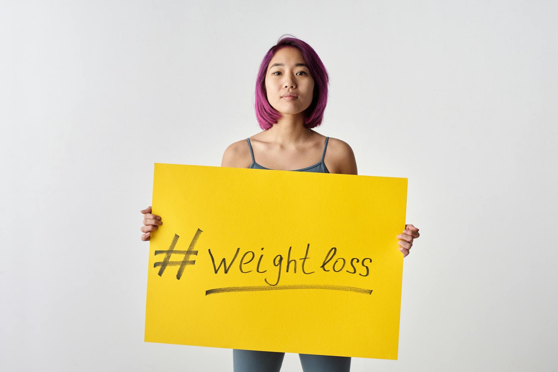 Azjatka z fioletowymi włosami trzymająca tabliczkę weight loss