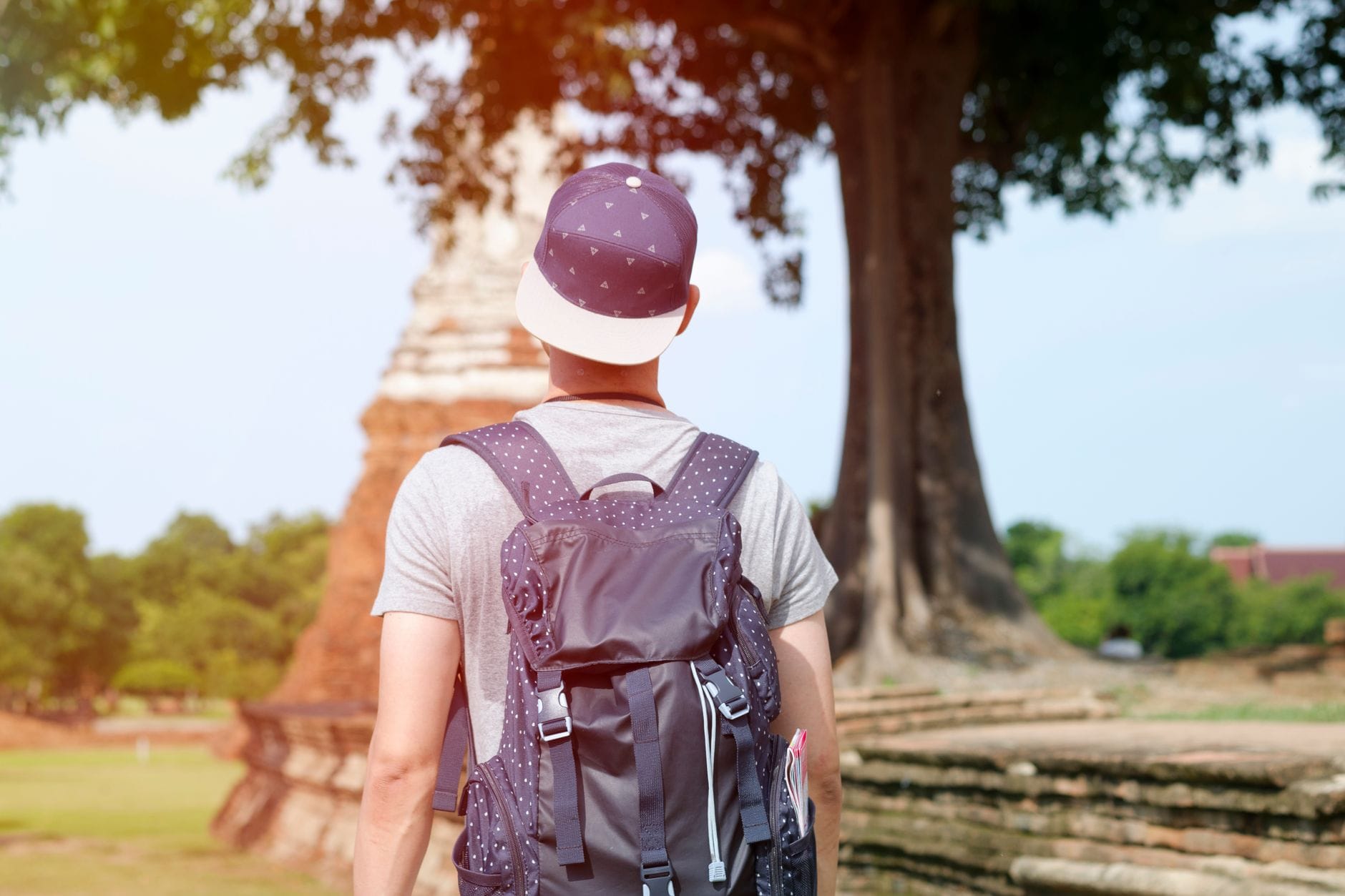 Młody backpacker zwiedzający ruiny świątyni w Tajlandii
