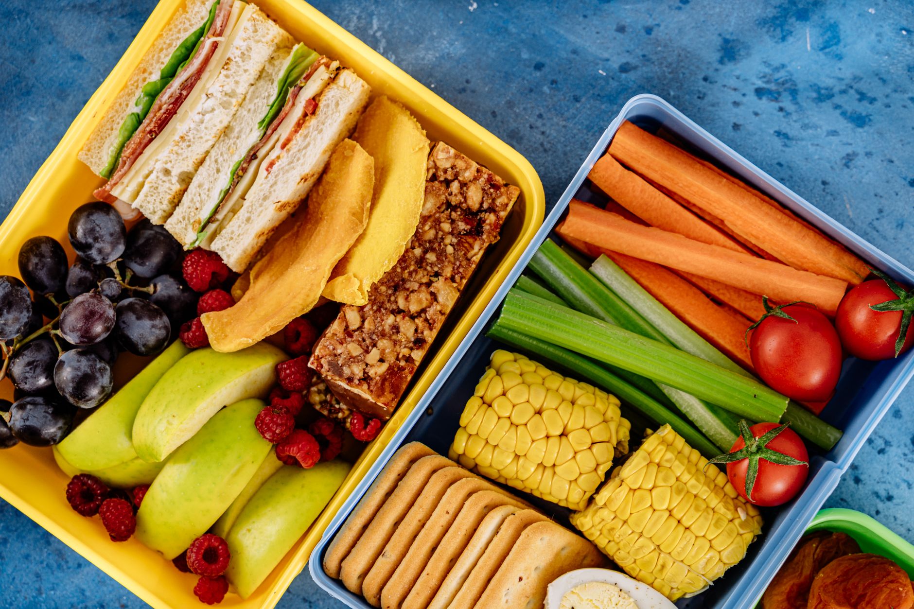 Zdrowy lunchbox z kanapkami, warzywami i owocami widziany z góry